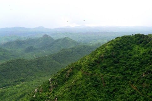 Aravalli Hills showing forested ridges alongside mining scars and dried water bodies, illustrating ecological degradation and groundwater stress in North India